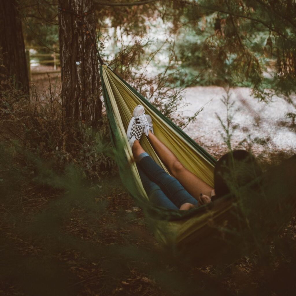 "An image of a person resting on a yoga mat, with their eyes closed and their body relaxed. The image represents the importance of rest and recovery in building muscle mass and preventing injury, emphasizing the need for balance between workouts and rest days.